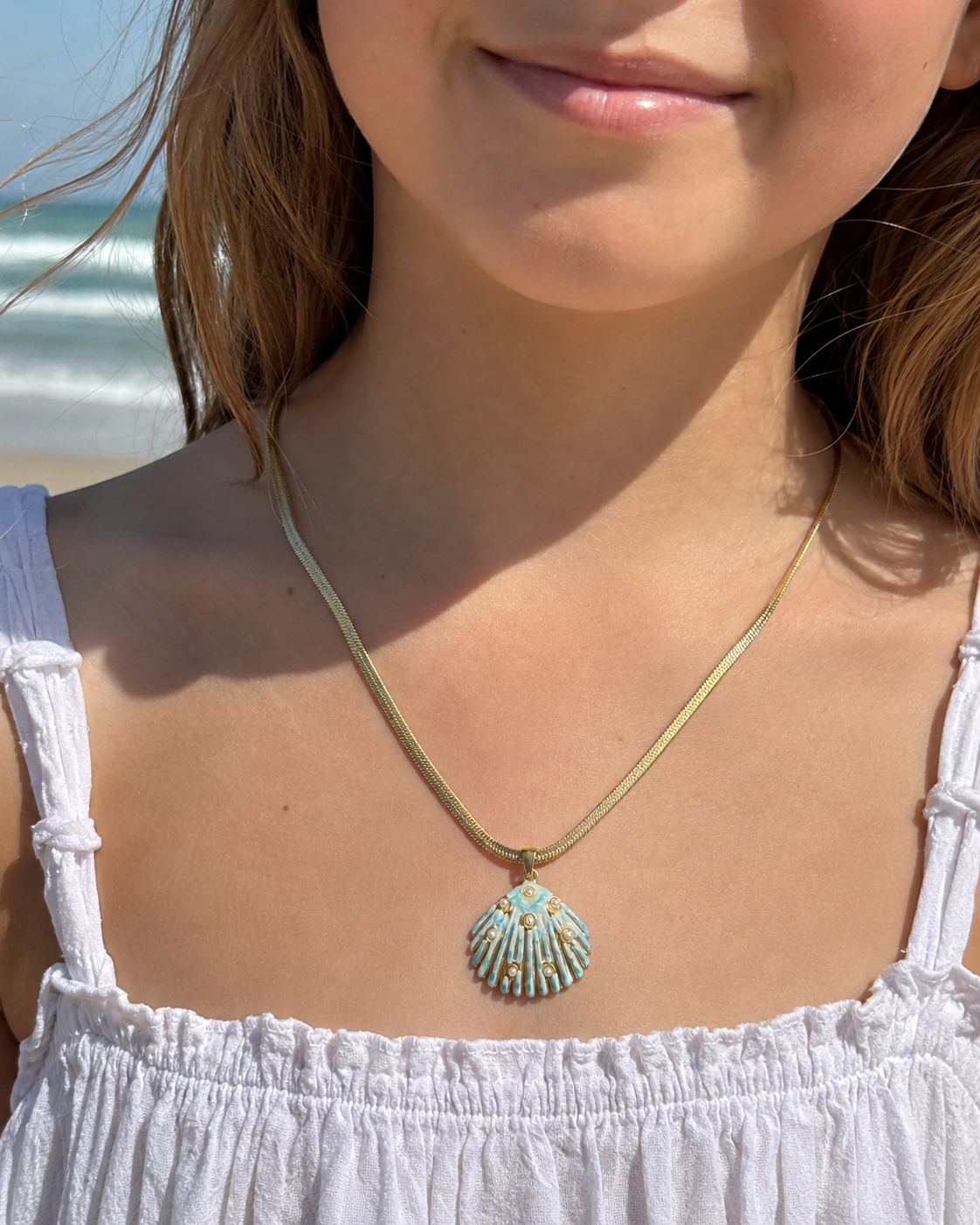 Styled view of Sea Glow Scallop Shell Necklace by AURAM with coastal shell pendant styling