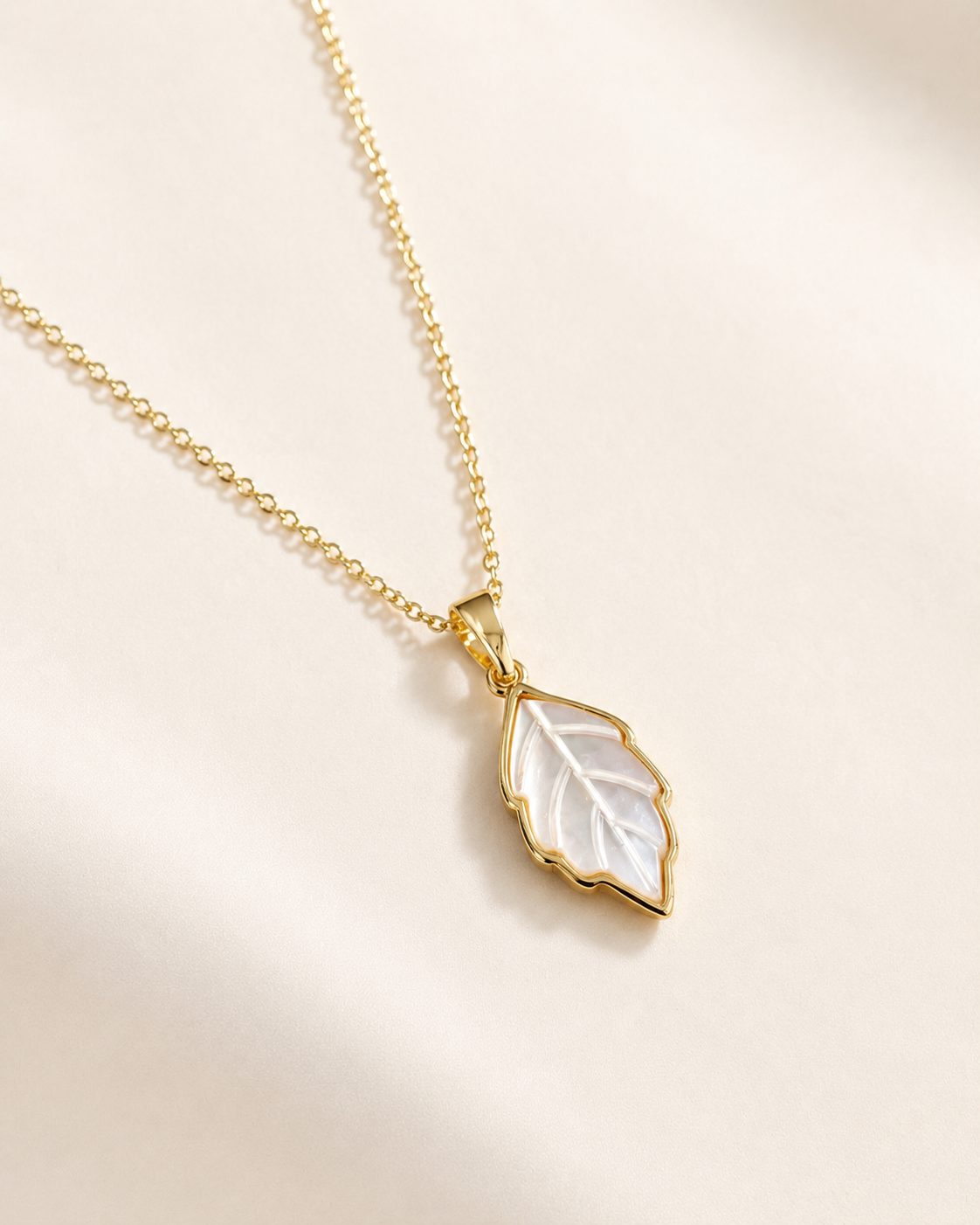 Styled view of Leaf Glow Mother-of-Pearl Pendant Necklace by AURAM with leaf-inspired shell pendant