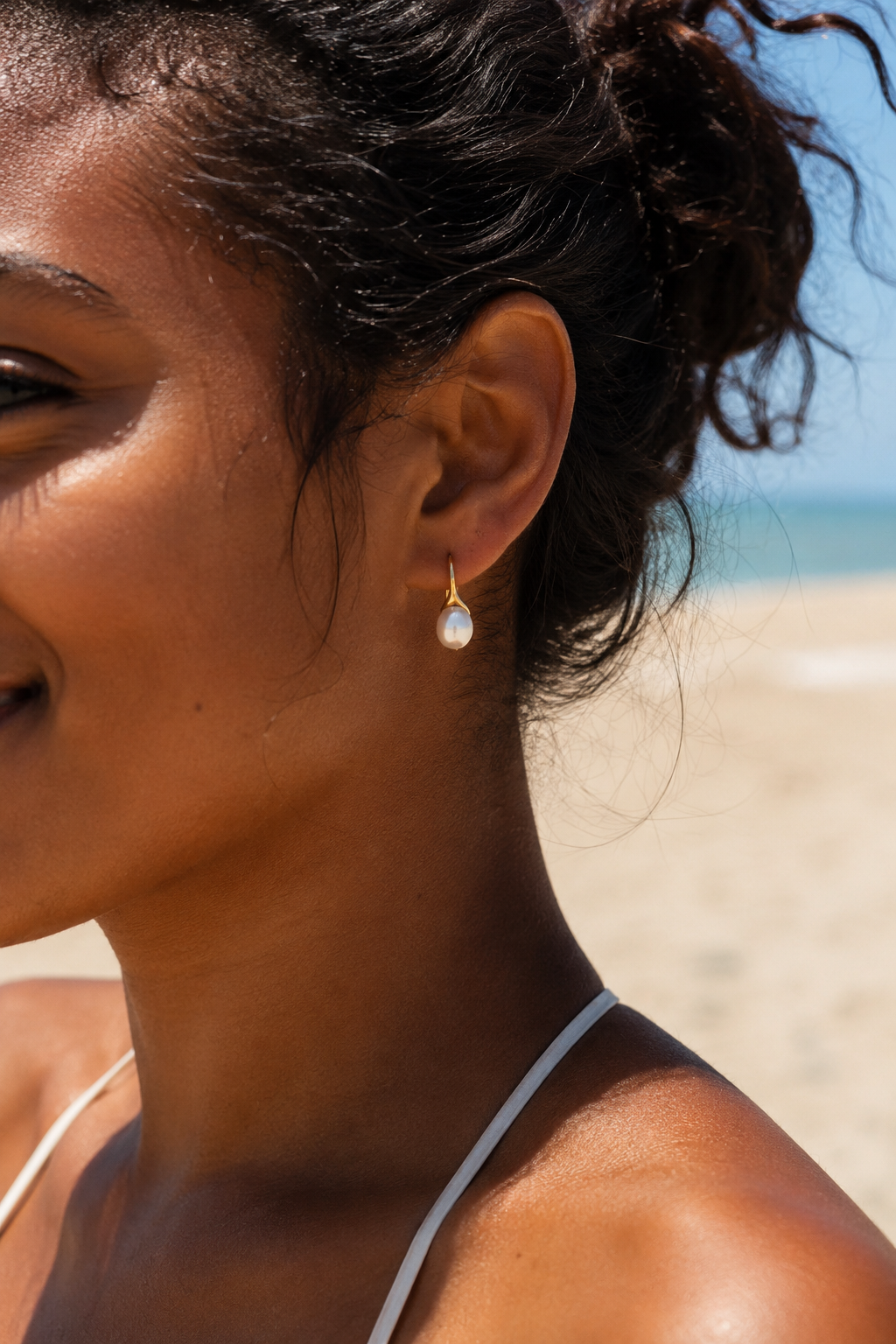Styled view of Luna Curve Pearl Earrings by AURAM, modern pearl earrings with soft gold-tone curve styling
