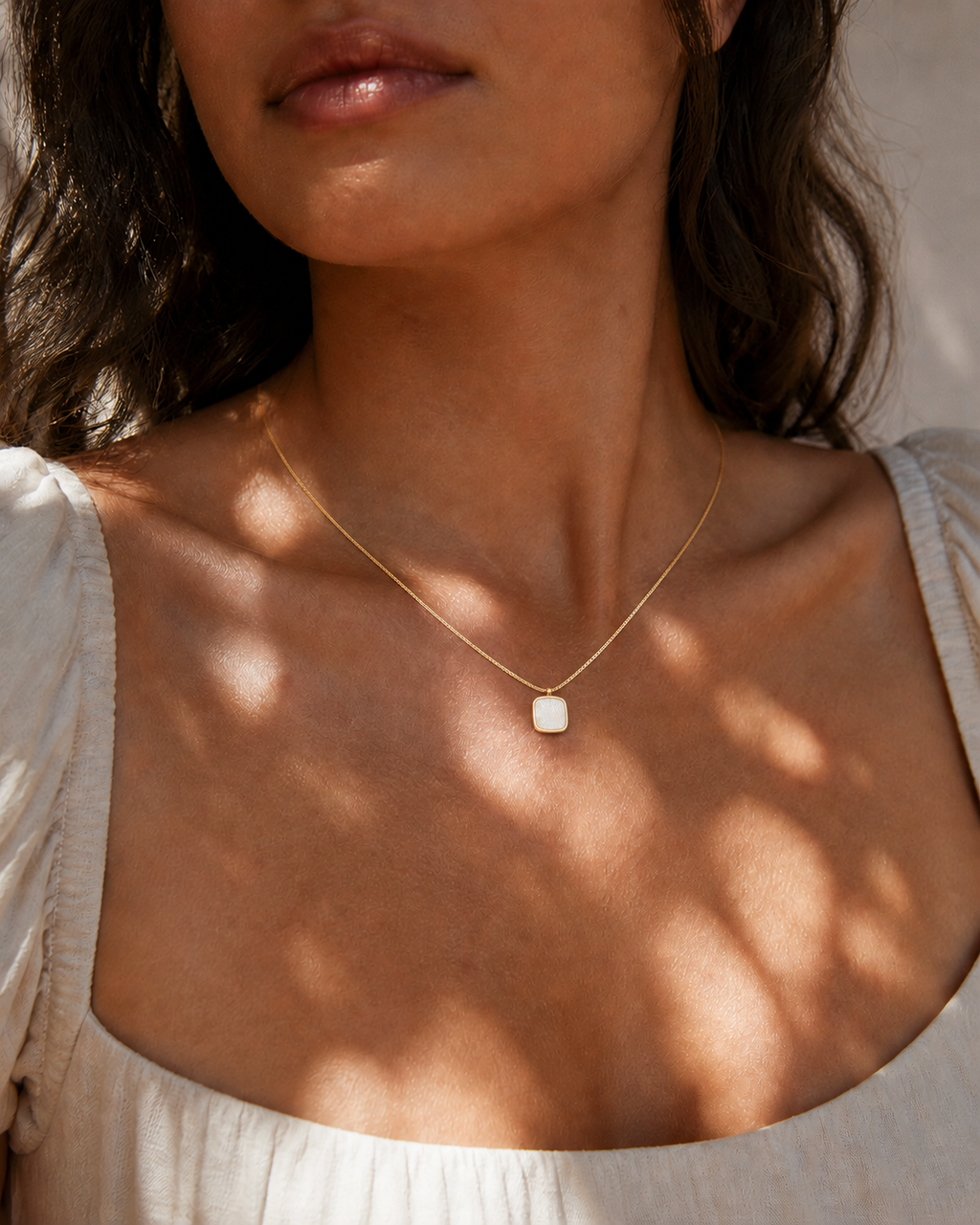 Detail view of Shell Glow Pendant Necklace by AURAM with luminous shell-style pendant and gold-tone chain
