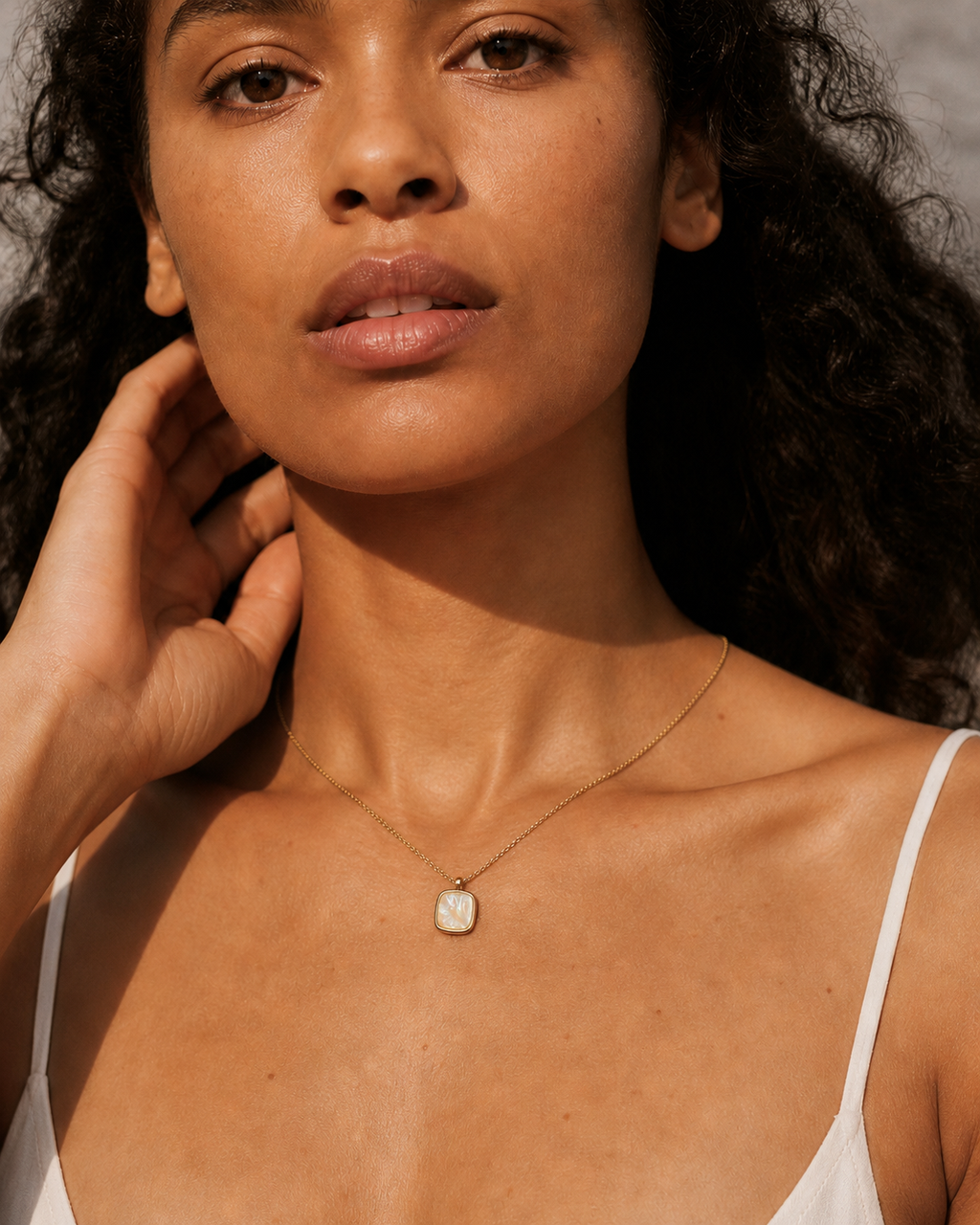 Styled view of Shell Glow Pendant Necklace by AURAM with luminous shell-style pendant and gold-tone chain